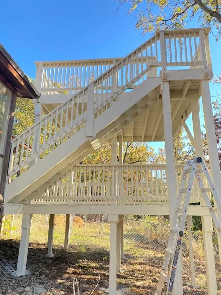 Two-level elevated deck and staircase freshly painted in cream