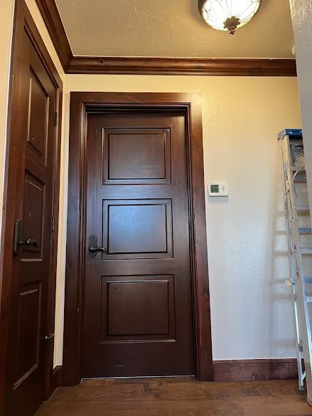 Stained three-panel interior doors with matching trim and crown molding