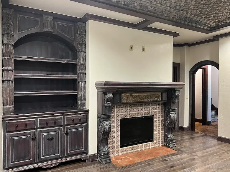 Hand-carved fireplace mantel and built-in shelves with a dark distressed finish